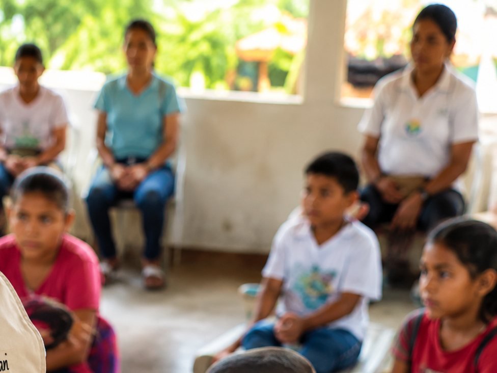 Integrante de la Corporación orientando un encuentro comunitario con niños, niñas y adultos